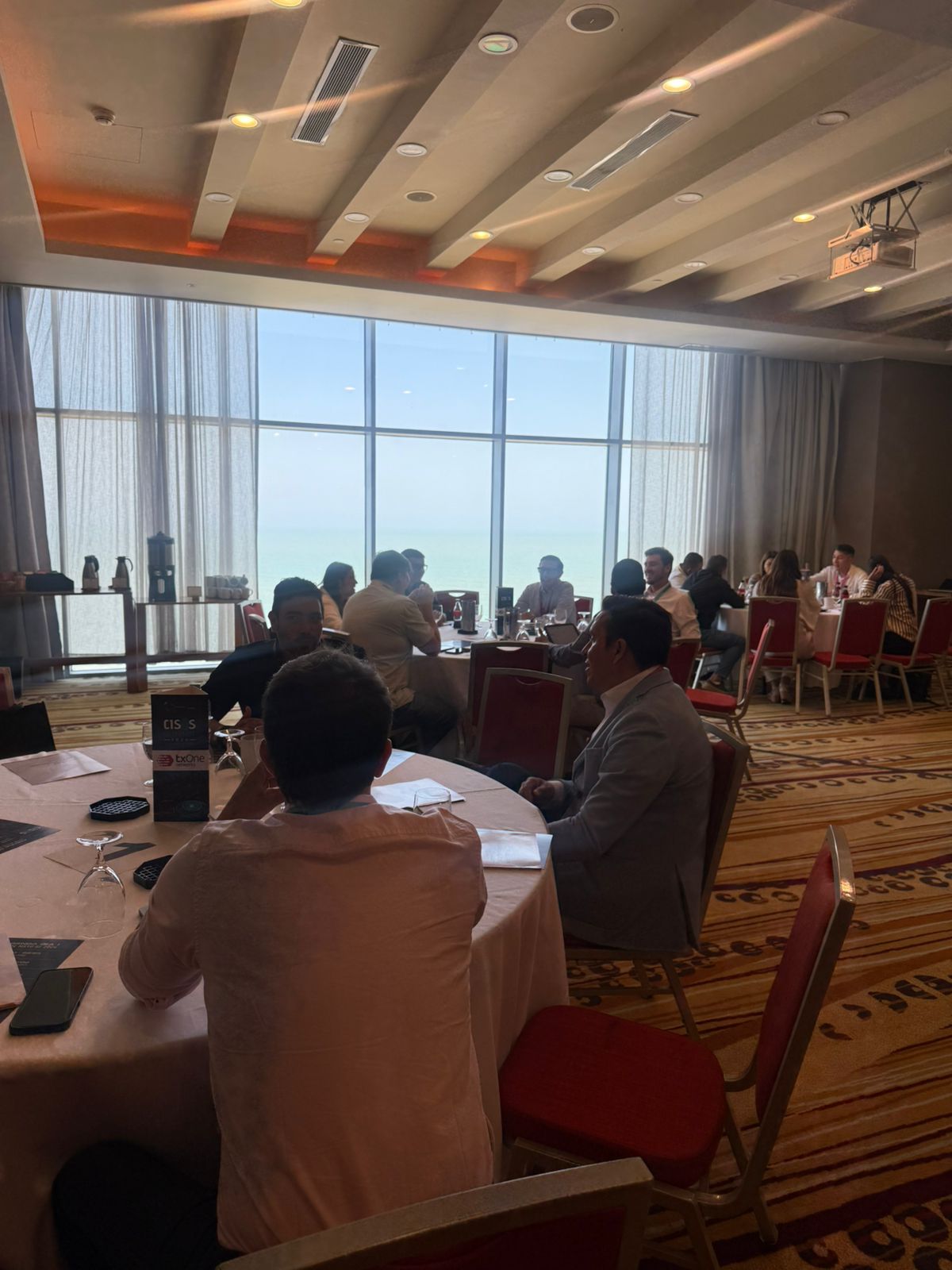 Roundtable against floor-to-ceiling windows with panoramic Caribbean horizon view